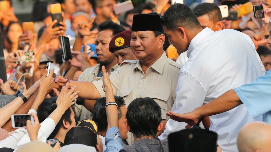 Indonesian presidential candidate Prabowo Subianto shakes hands with supporters.