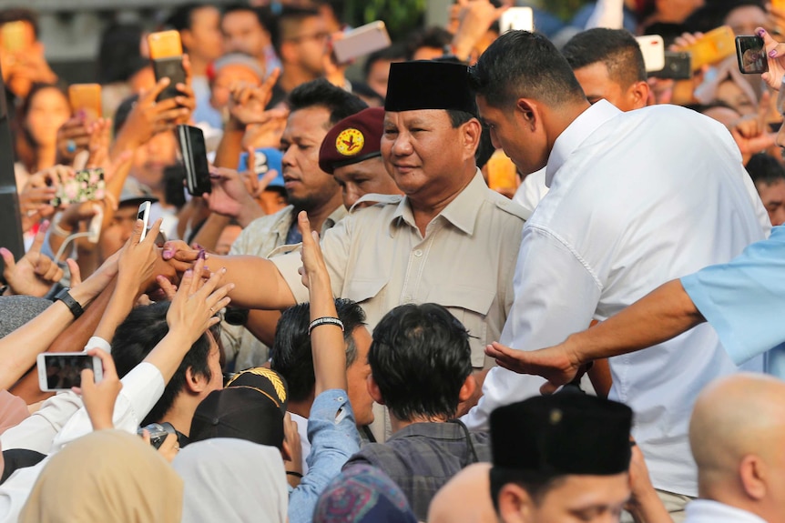 Indonesian presidential candidate Prabowo Subianto shakes hands with supporters.