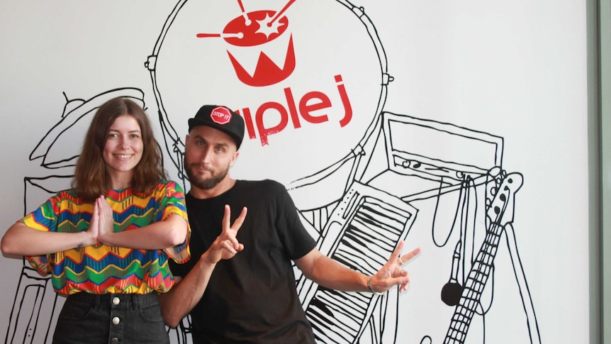 Bridget and Fisher standing in front of the triple j red drum mural