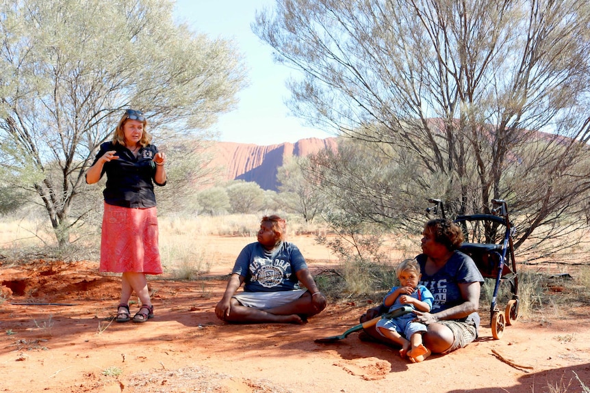 Tracey Guest talking with Anangu women in front of Uluru