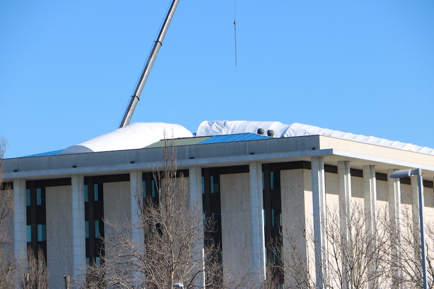 Large white plastic wrapped repairs on the roof of the National Library in Canberra.