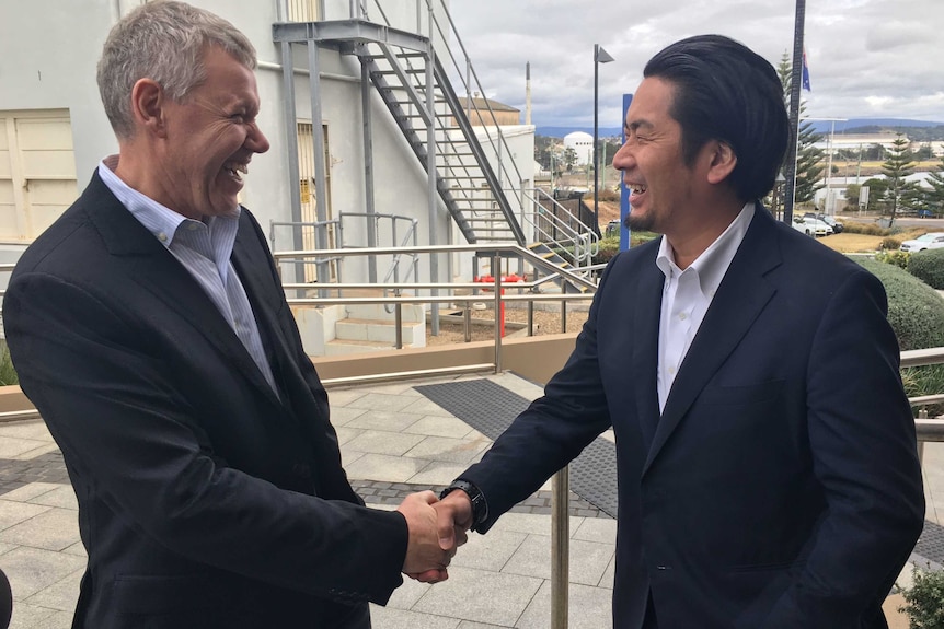 Australian Industry Energy's James Baulderstone and JERA's Ken Ohyama shake hands at Port Kembla.