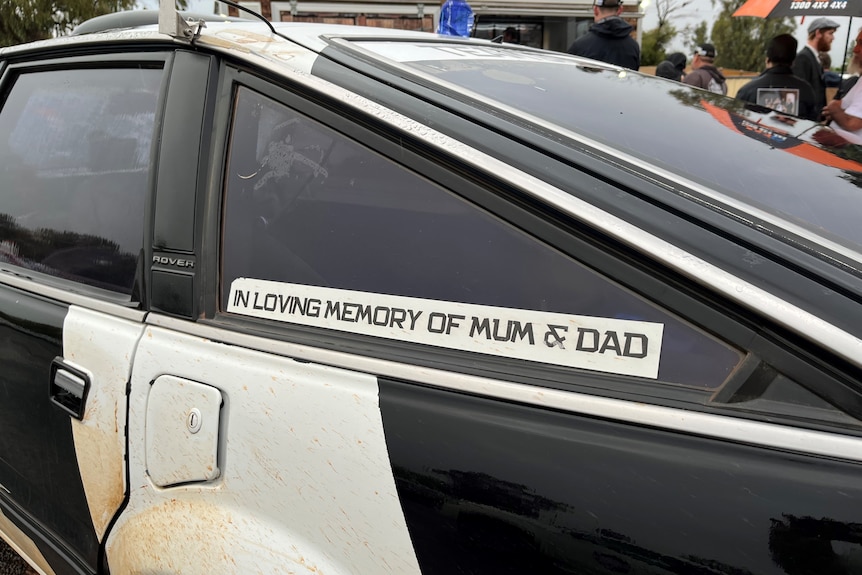 A black and white car with the with the words in loving memory of mum and dad.