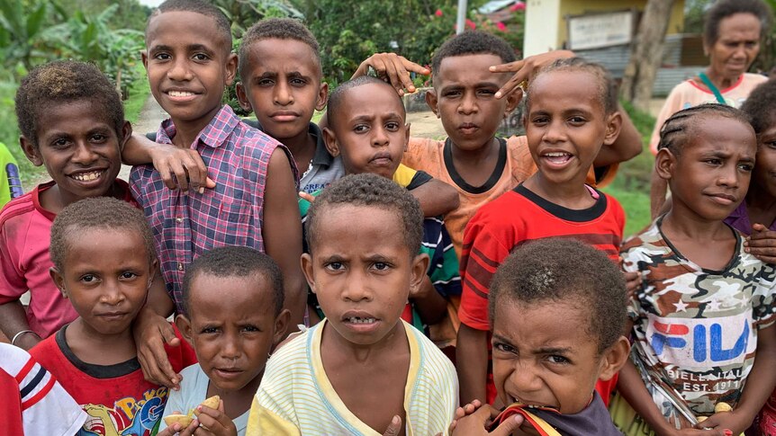 A group of smiling children pose for a photo in West Papua.