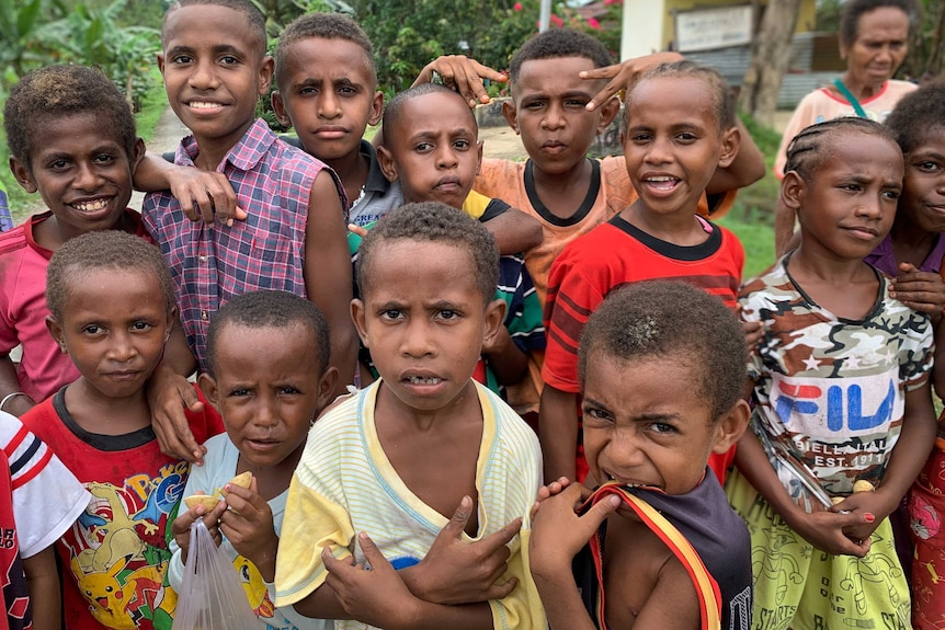 A group of smiling children pose for a photo in West Papua.