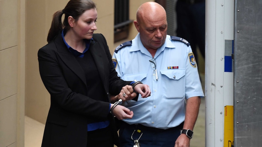 Harriet Wran being escorted to a prison transport vehicle at the NSW Supreme Court.