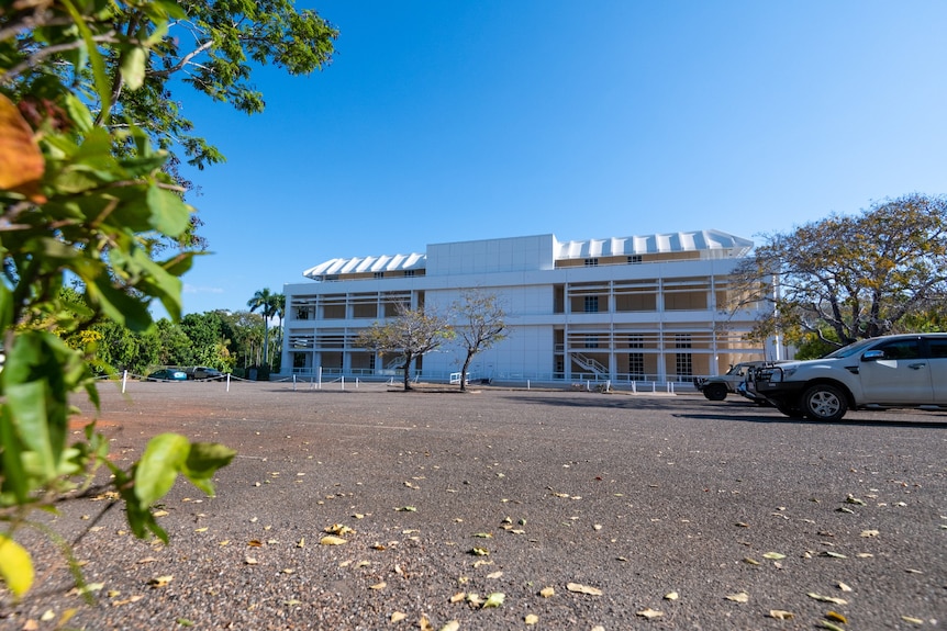 A large empty carpark next to the Supreme Court on a sunny afternoon.