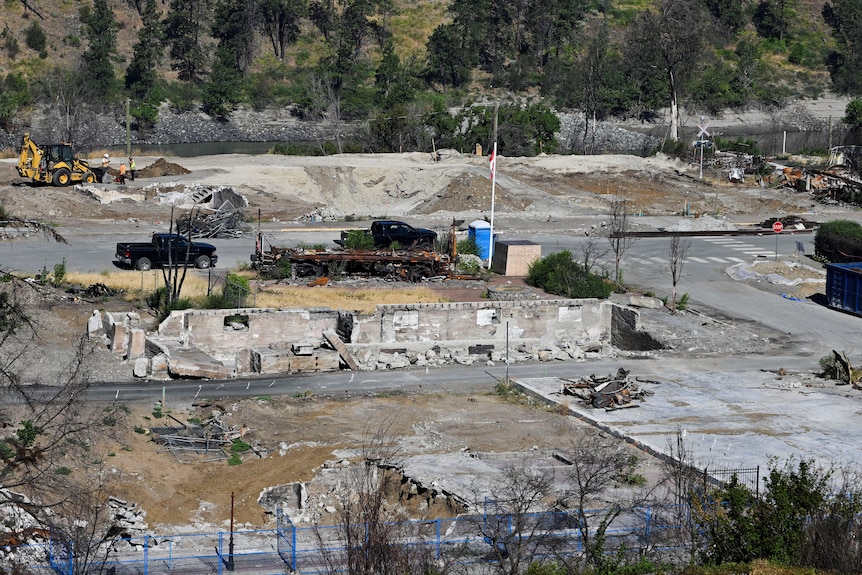 Small piles of construction material sits among burned patches of ground on concrete housing blocks.