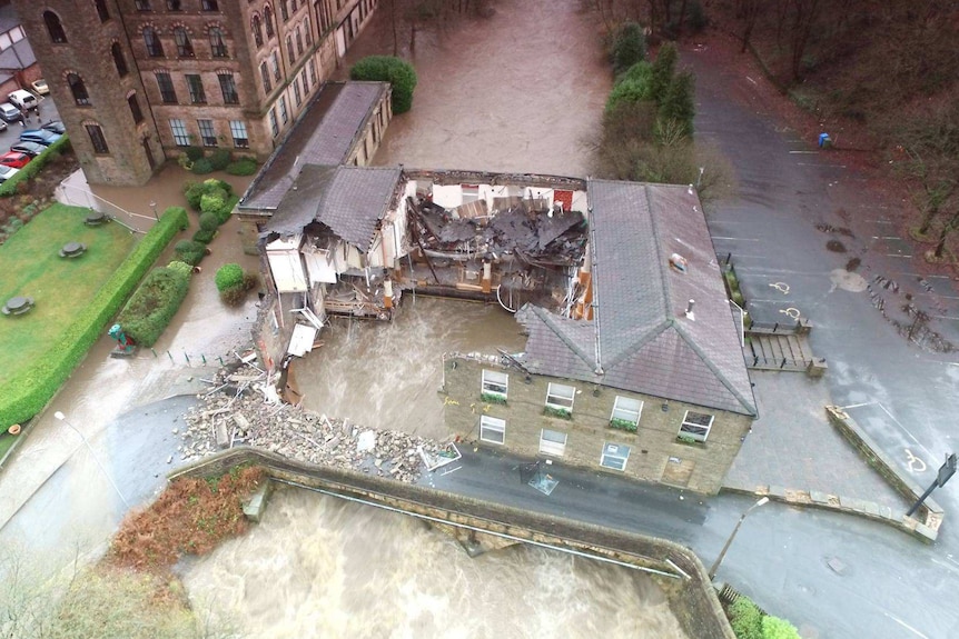 Water washes through the collapsed Summerseat Pub.