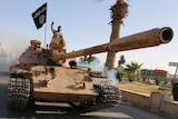 Islamic State fighter on top of tank in Syria