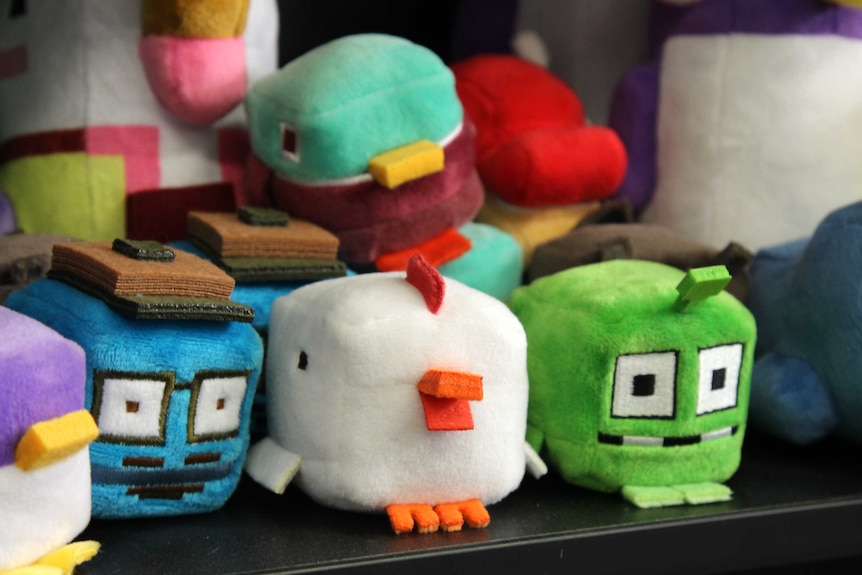 A shelf full of small plush toys, which includes a whale and a chicken.