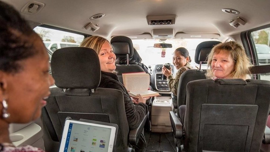 Ladies in a shuttle bus going to work.