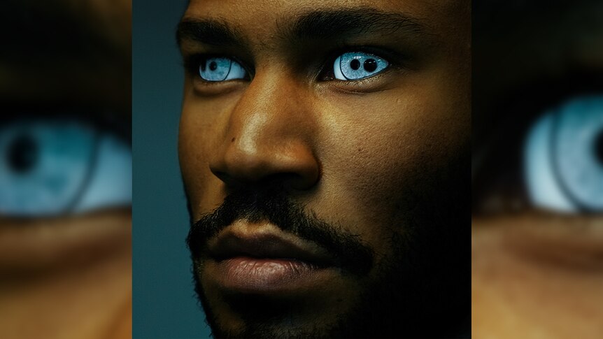A close up photo of a man with bright blue eyes and two extra pupils