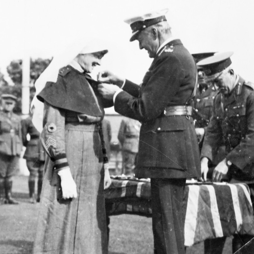 Lord Forster, Governor General of Australia (right), presenting the Military Medal to Staff Nurse Pearl Corkhill, 5 June 1924.