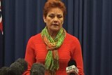 Pauline Hanson stands at a press conference