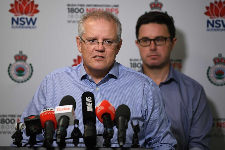 Scott Morrison speaking behind a set of microphones at RFS headquarters with David Littleproud behind him
