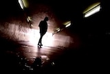 Young person silhouetted in underpass generic image.