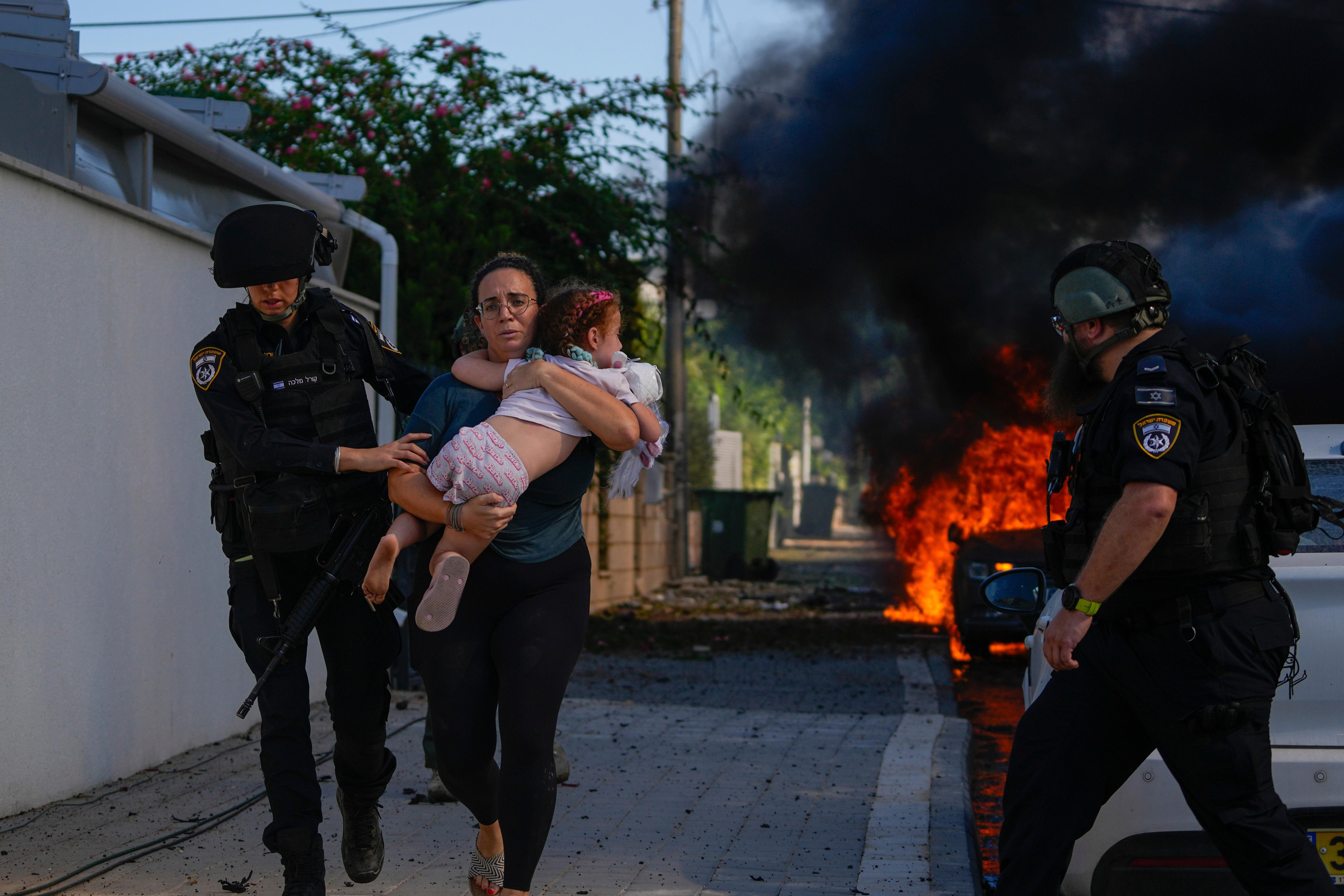 Police officers evacuate a woman and a child.