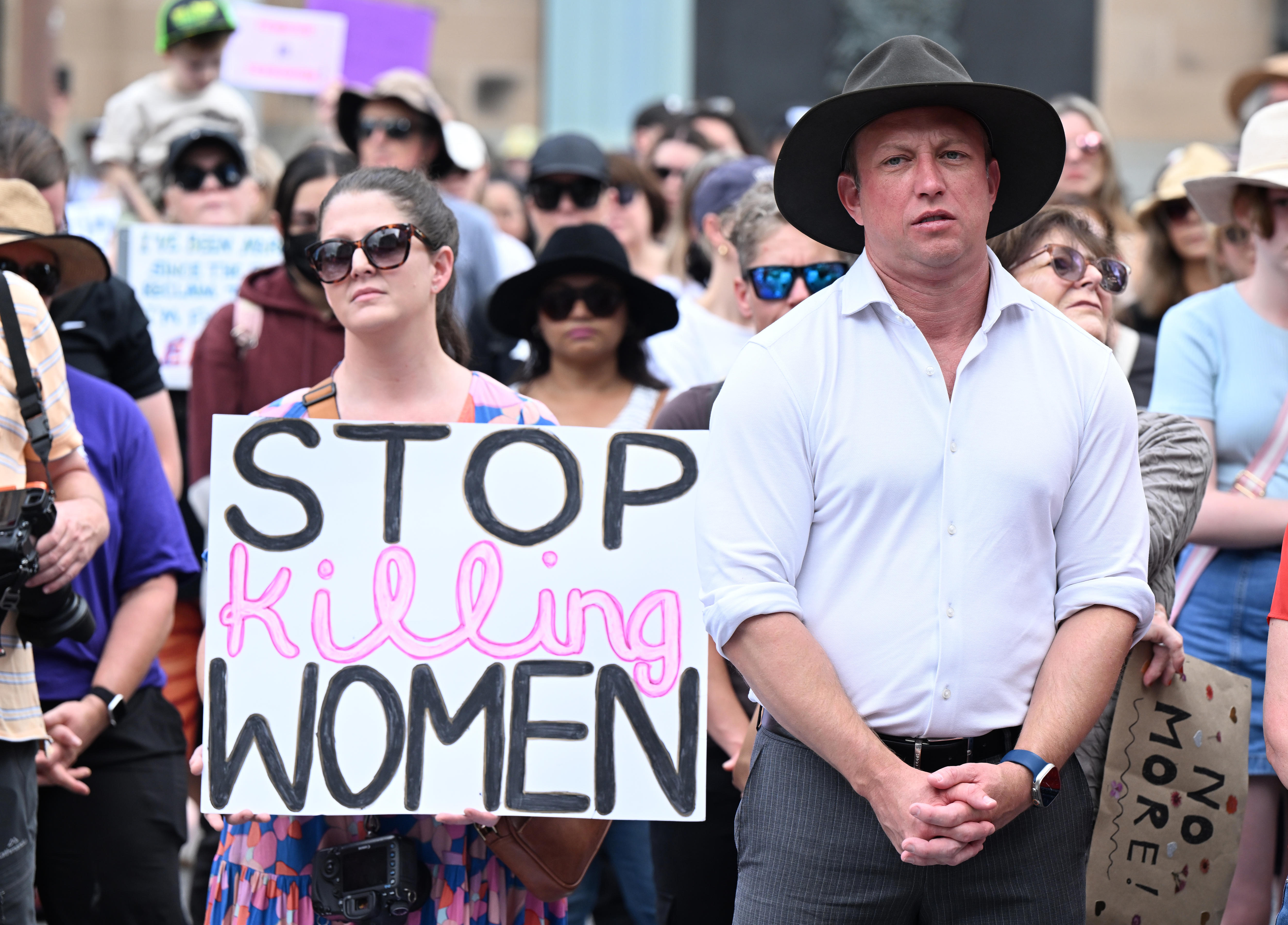 Steven Miles stands during a rally to a call for action to end violence against women.
