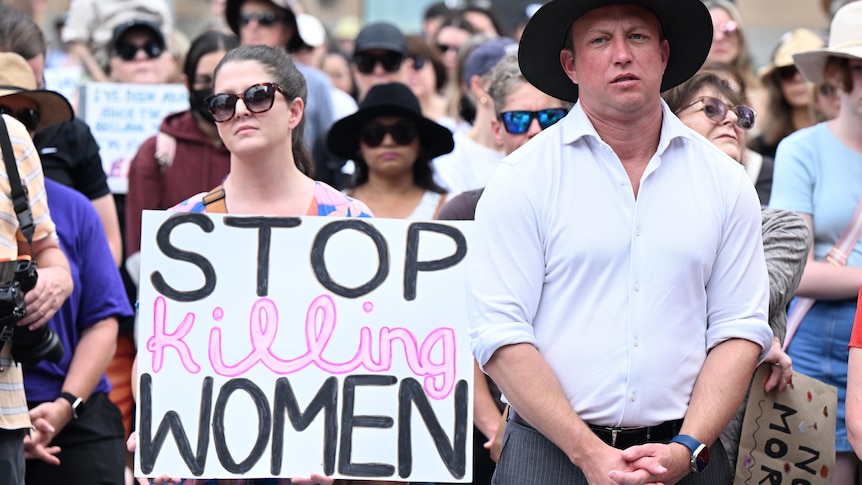 Steven Miles stands during a rally to a call for action to end violence against women.