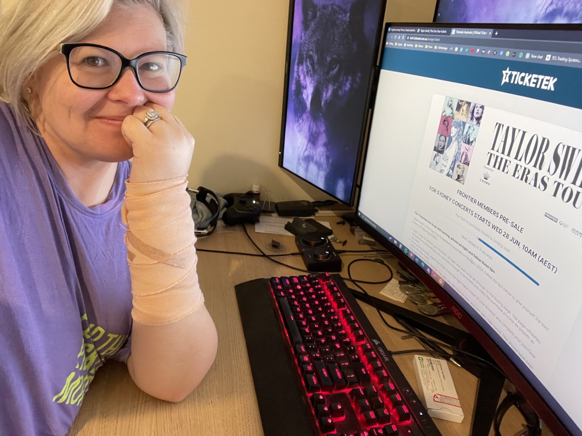 A woman poses in front of a computer screen showing the Taylor Swift tour on the Ticketek website. 