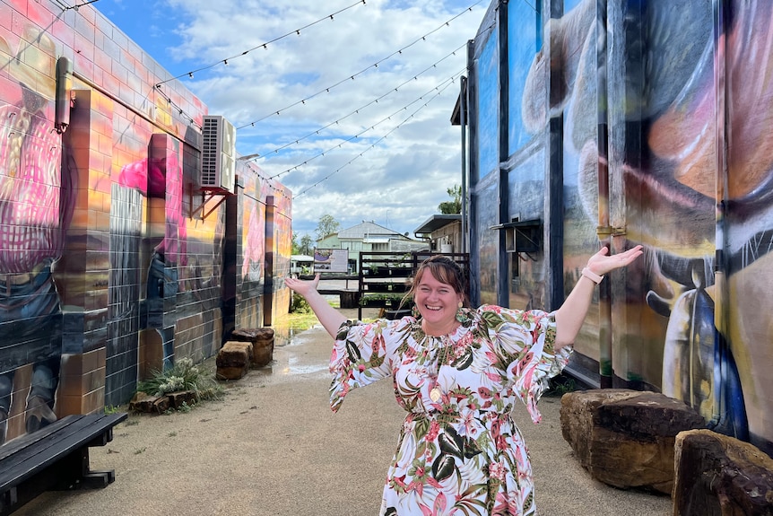 A woman wearing a floral dress smiles