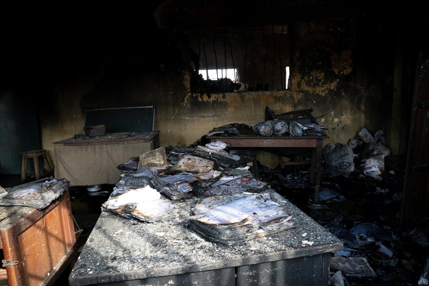 Burnt prison books are scattered across a table after gunmen attacked the prison and set it on fire, April 5, 2021.