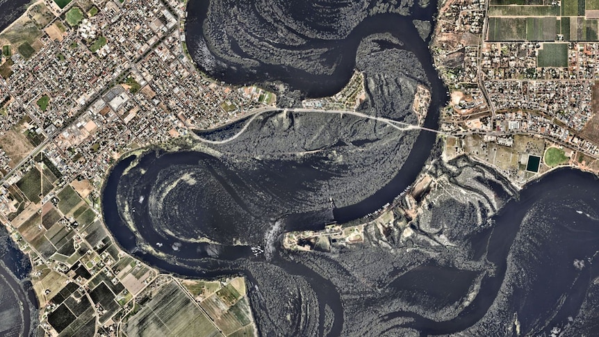 An aerial image of two towns on either side of a flooded river