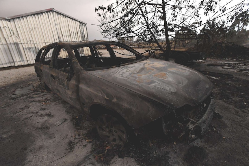 A blackened, burnt out shell of a car.