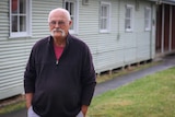 John Martins-Kelmins outside one of the huts at Bonegilla.