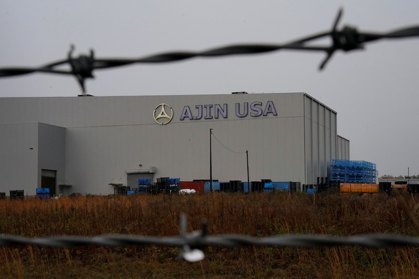 view of the Ajim manufacturing faclity in Alabama through barbed wire