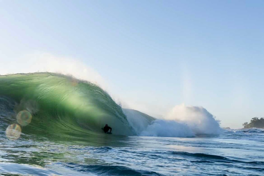 A bodyboarder in the barrel of a wave.