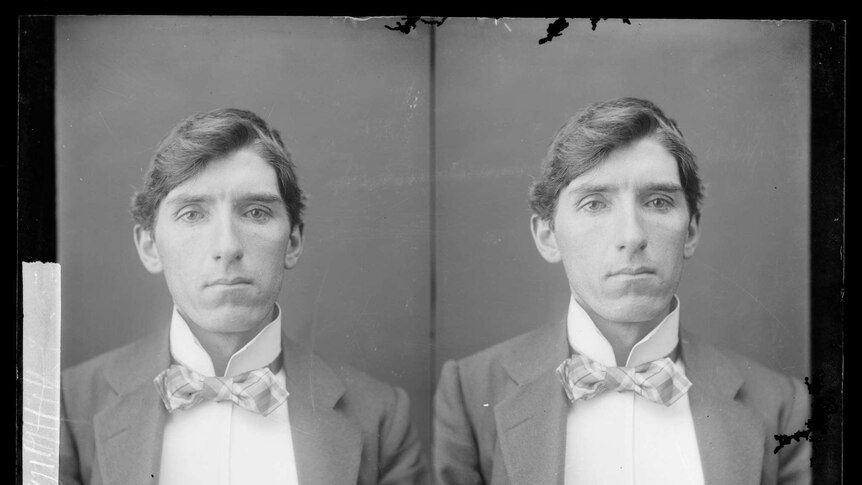 Black and white police photograph of a man in a suit and bow tie from the 1800s.