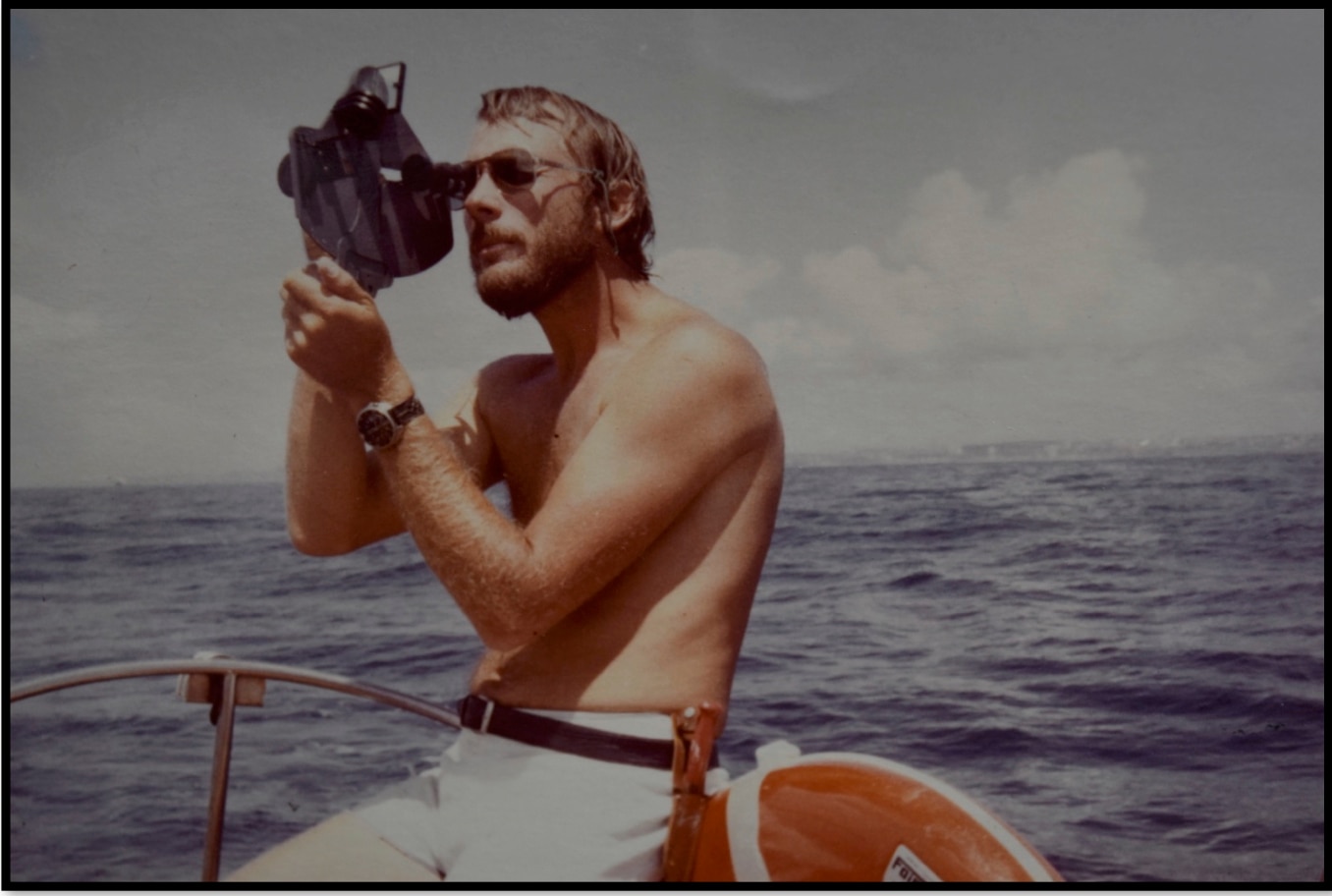 a young man taking a photograph on a boat.