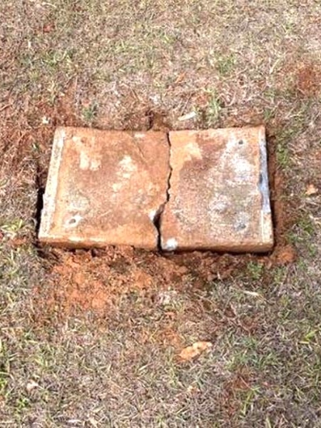 A concrete tombstone smashed in half, with no plaque.