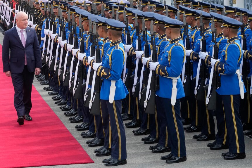 New Zealand's Prime Minister Christopher Luxon reviews an honour guard of uniformed personnel during a welcome ceremony