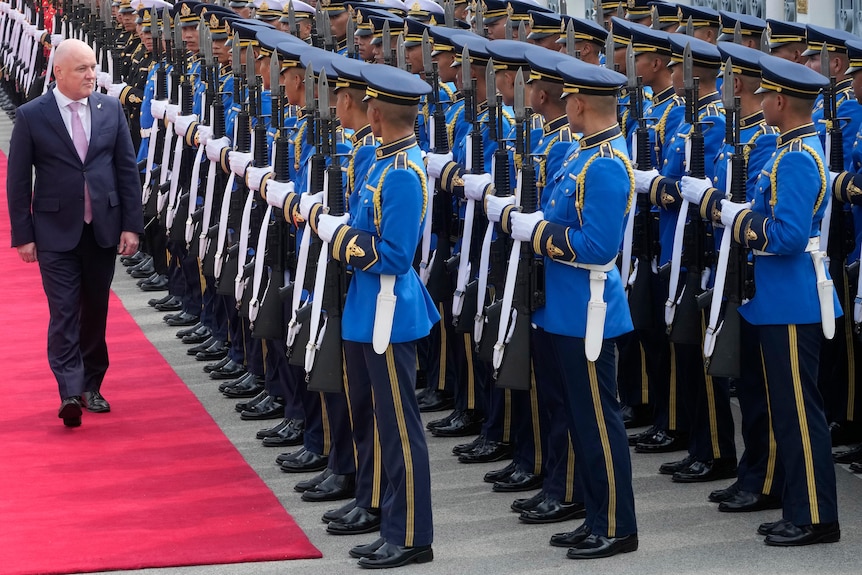 New Zealand's Prime Minister Christopher Luxon reviews an honour guard of uniformed personnel during a welcome ceremony