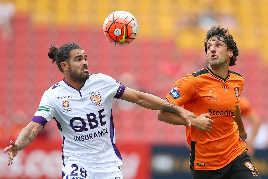 Aryn Williams of the Glory and Thomas Broich of the Roar compete for the ball