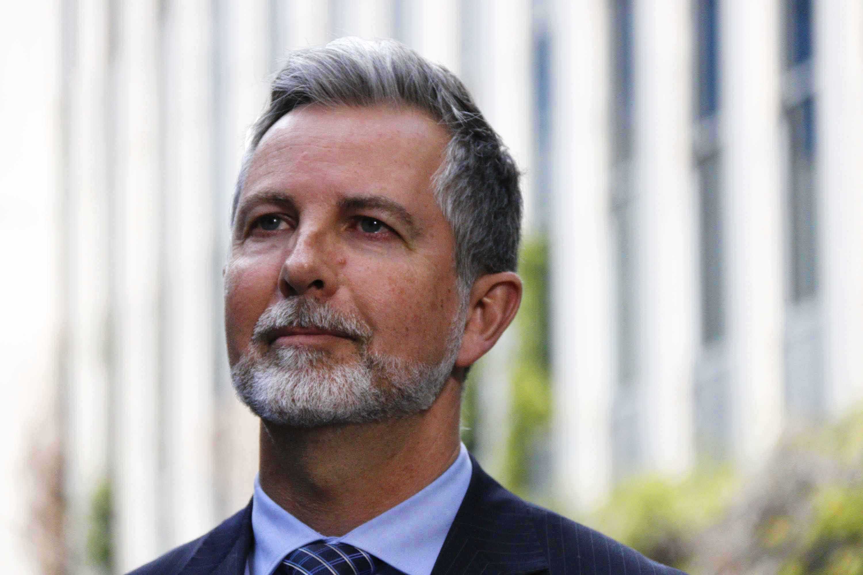 Liberal MLA Jeremy Hanson in front of Legislative Assembly looking off behind the camera.