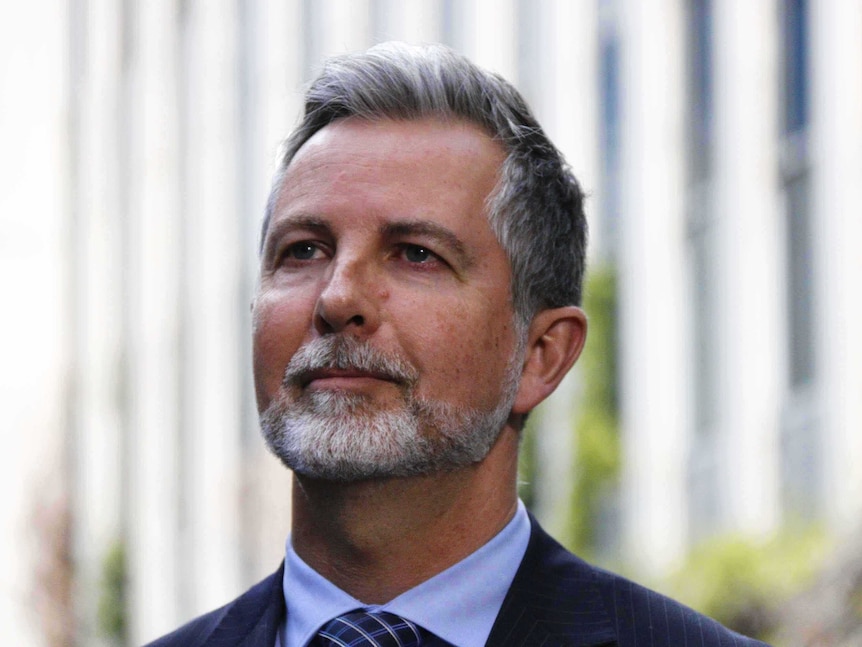 Liberal MLA Jeremy Hanson in front of Legislative Assembly looking off behind the camera.