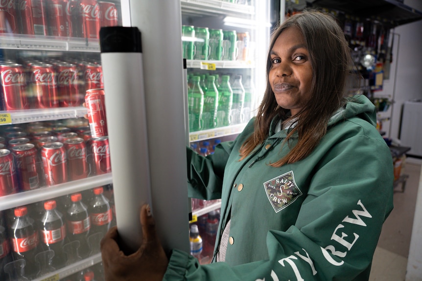 Joanne Baker stacking a fridge with soft drinks