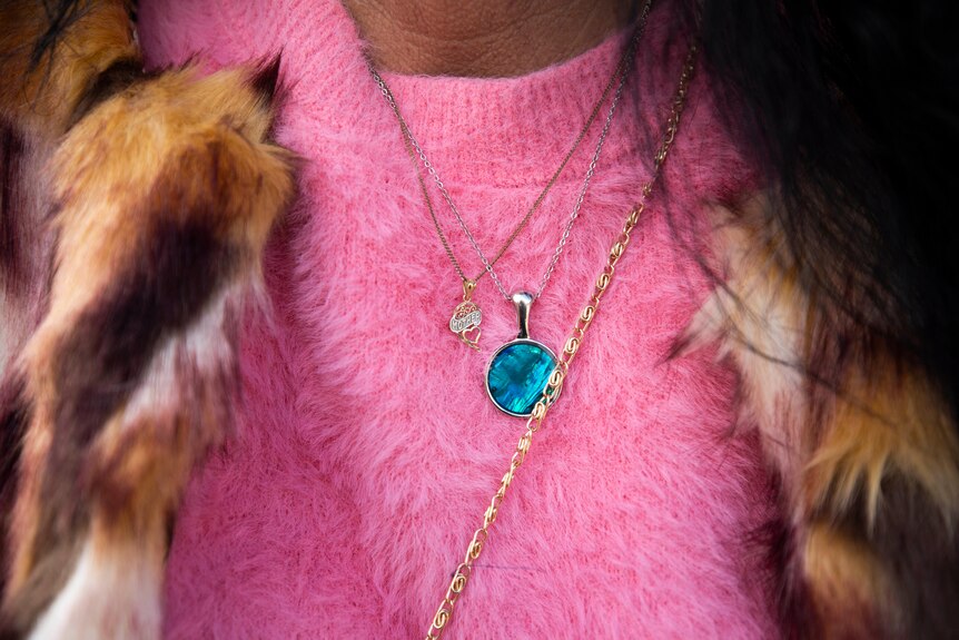 Blue necklace on a pink jumper