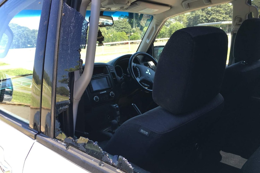 The interior of a van, as ween through a smashed window.