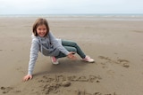 Heather Bowden-Page plays in the sand on the beach.