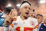 Patrick Mahomes raises his right hand as he celebrates the Chiefs' winning the Super Bowl.
