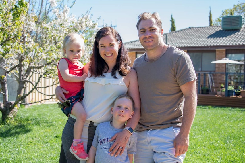 Kirsten Davey and her family in front of their home.