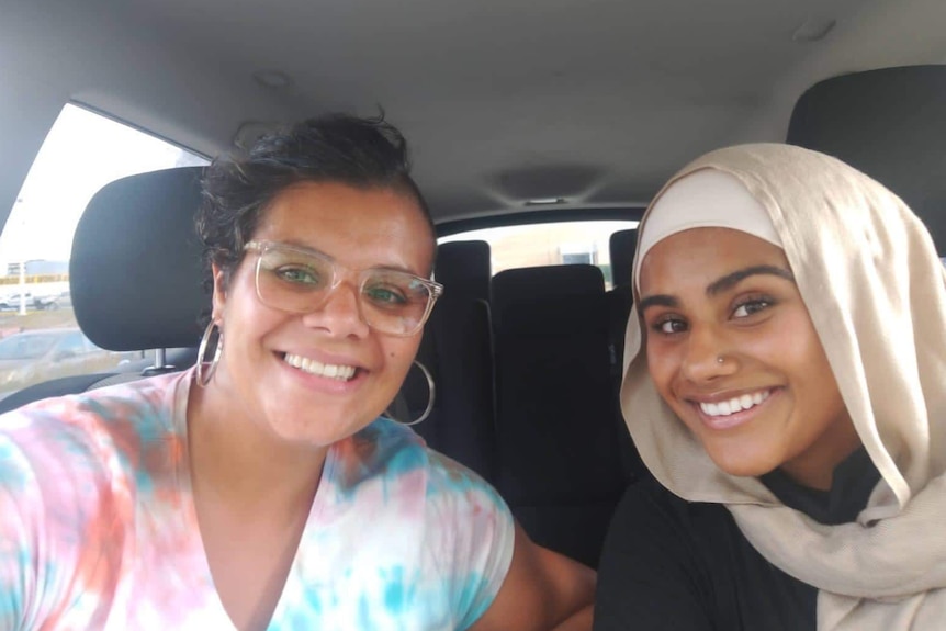 Two women taking a photo in a car.