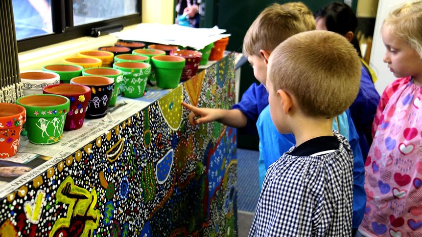 Children admiring their painting.