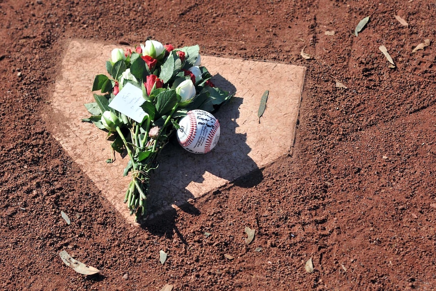 A tribute to Chris Lane is left on home plate at Essendon Baseball Club