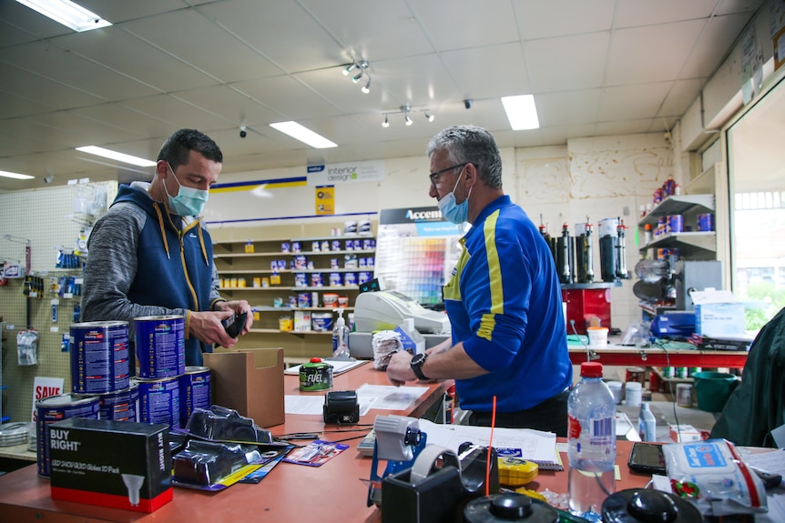 A man serves a customer at a hardware store
